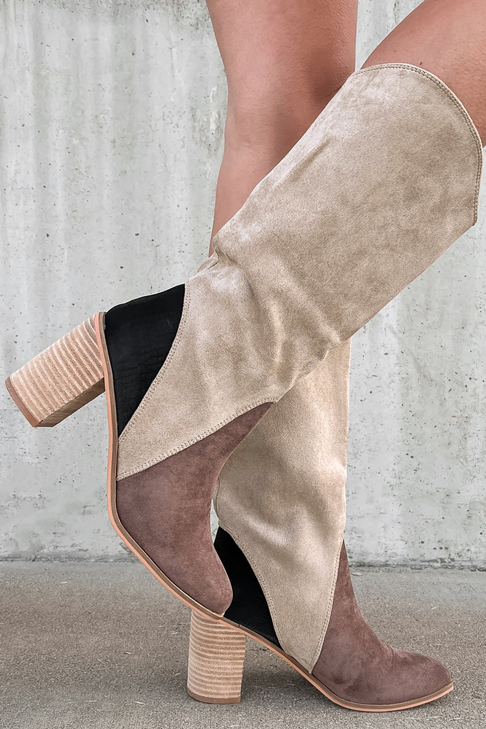 Beige and brown suede boots with block heels on a neutral background