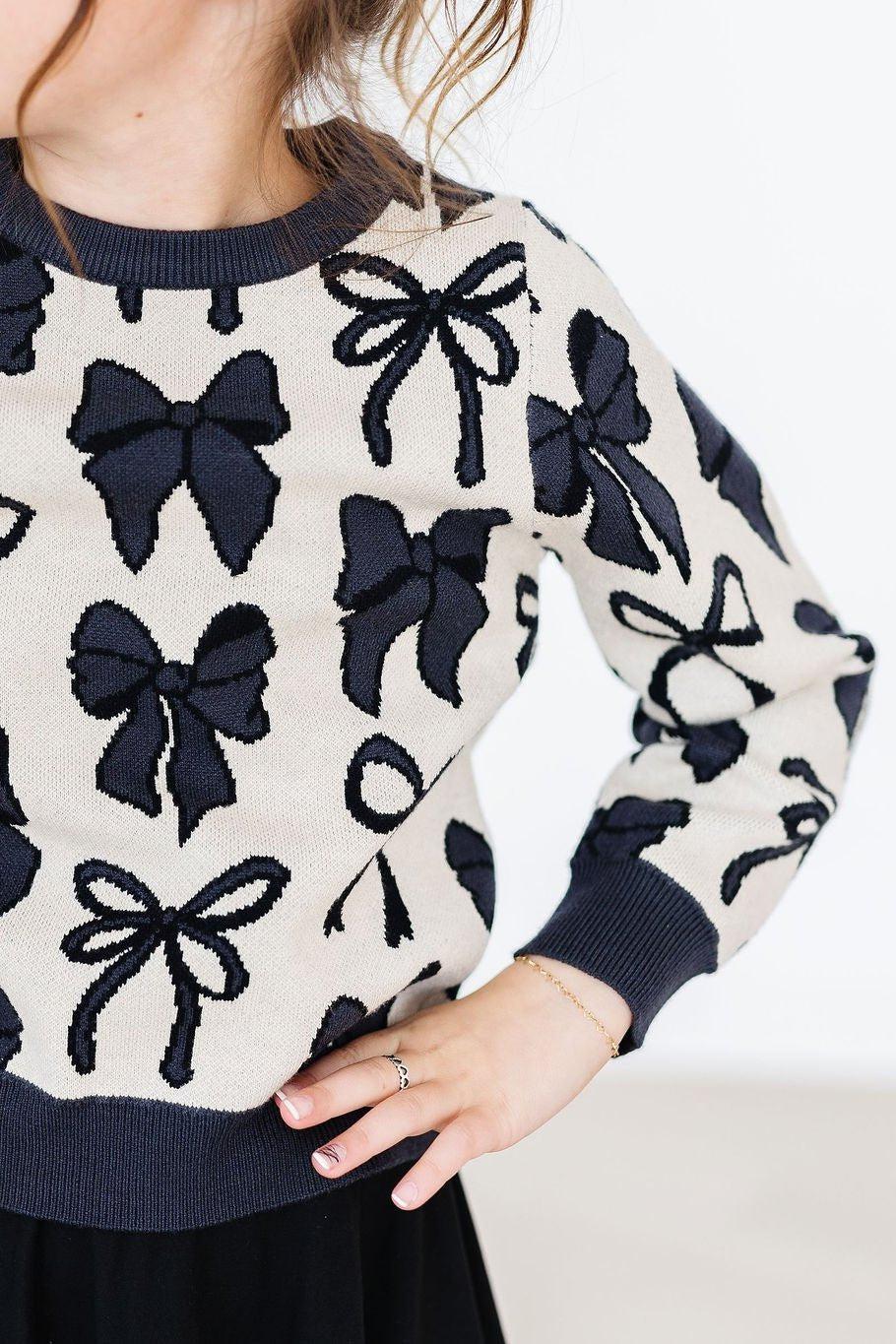 Sweater with black bow pattern on a white background