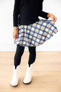 Person wearing a plaid skirt with a white background