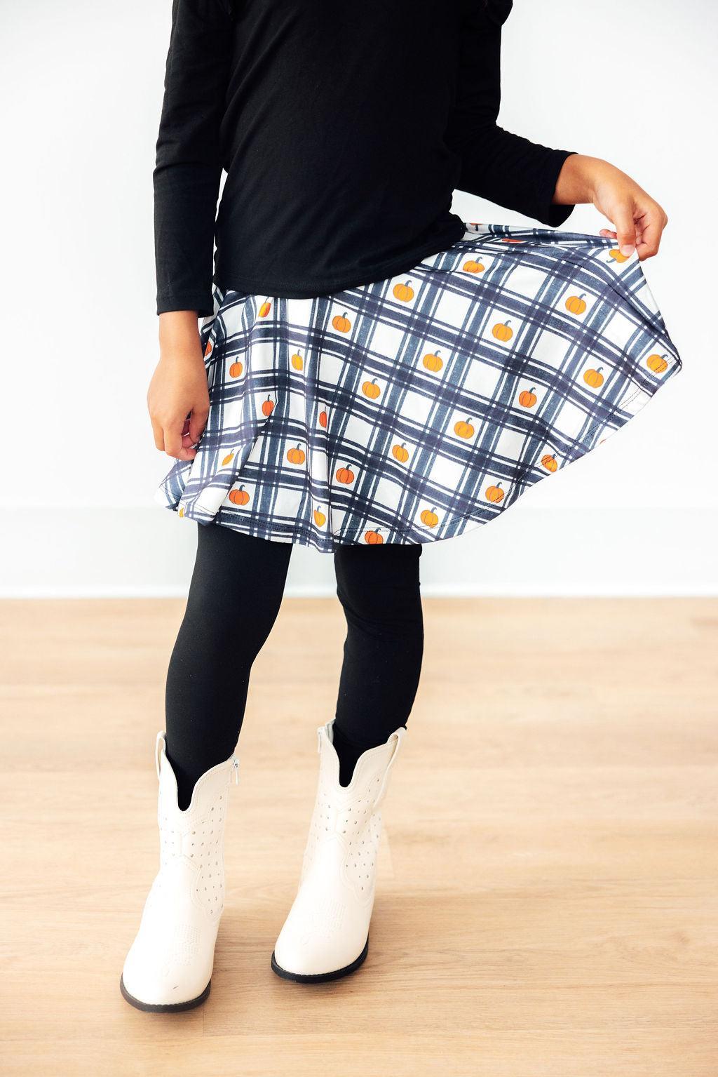 Person wearing a plaid skirt with a white background