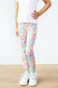 Person wearing colorful pumpkin-patterned leggings on a white background